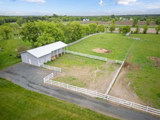 Second outbuilding - horse barn with concrete floors, ethernet, and three horse stalls leading to a fenced-in area.