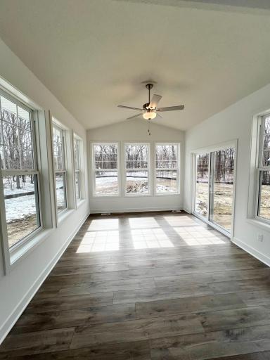 Four season porch with vaulted ceiling and ceiling fan.