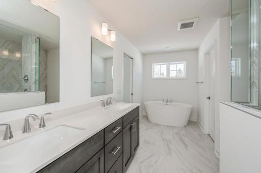 Primary suite bathroom with walk in shower and free sstanding bathtub.jpg