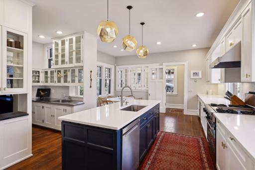 Spacious center-island kitchen with updated lighting, new finishes, and refinished hardwood floors.