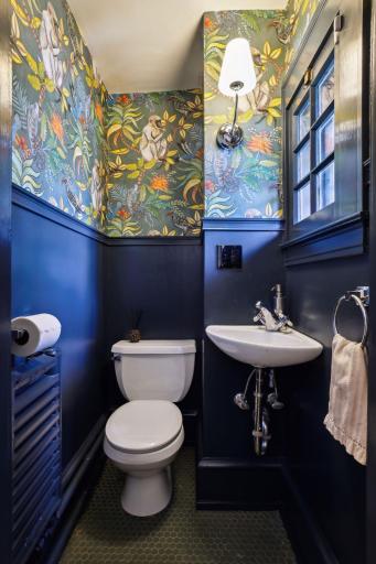 Discreet main level powder room near side entrance.