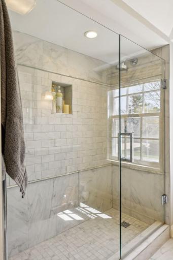 Glass enclosure shower with floor to ceiling tile.