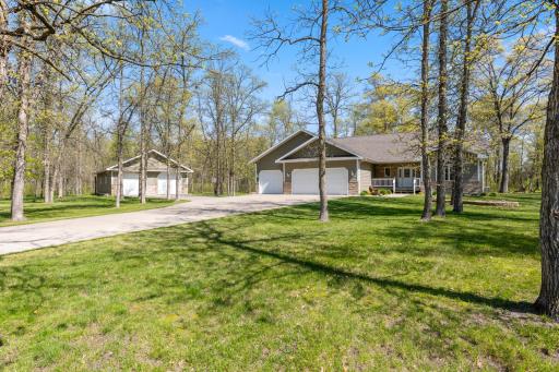 Ideal setting nestled in the woods. Property is crafted with quality products throughout- cement board siding, maintenance free decking, concrete drive, insulated/heated garage, pole shed to match the homes exterior, + concrete landscape edging.