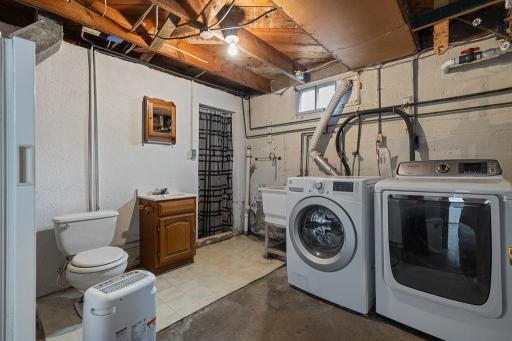 The lower level features the laundry room, which doubles as a secondary bathroom with an additional toilet and shower space
