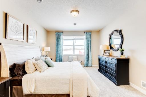 Primary bedroom with private en suite and walk-in closets has space for all of your bedroom furniture needs. Model photo. Options and colors will vary in our available inventory homes.