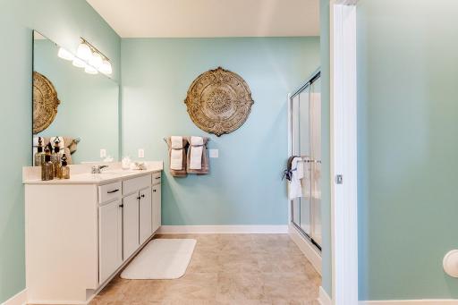 Fantastic primary en suite with separate vanities, quartz countertops and a large walk-in closet with wire shelving included. Model photo. Options and colors will vary in our available inventory homes.