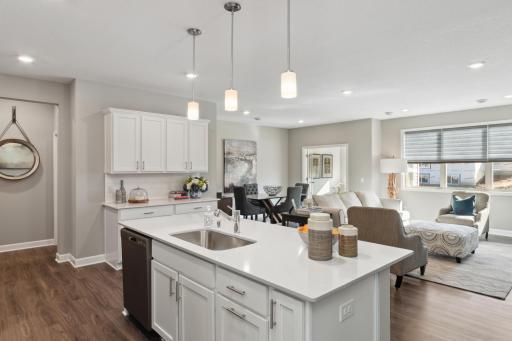 (Photo of completed model home, actual home's finishes vary) Beautiful brushed nickel cabinet hardware and pendent lighting enhance the kitchen space, making it the perfect spot to cook dinner.