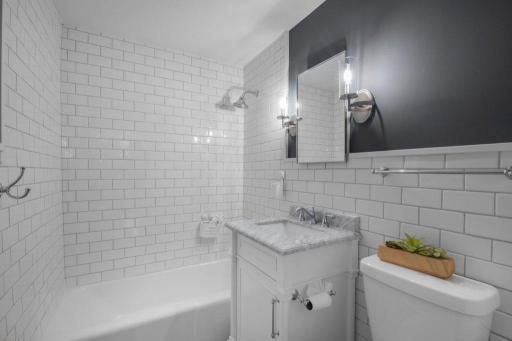 The second-floor full bath features classic white subway tiles on the walls.