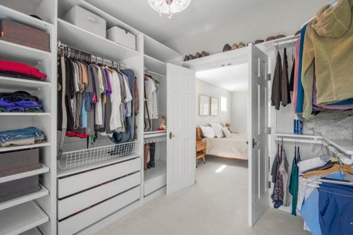 This bedroom features a spacious walk-through closet. The closet is a generous size.