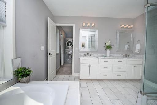 View of the double vanity, beautiful tile work and large walk-in shower with double shower heads.