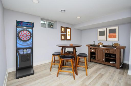 The lower-level card/bar area is perfect for gathering friends and family for the big game, holidays or watching your favorite movie. Area behind the refrigerator is plumbed for a walk-up bar. Visually staged.