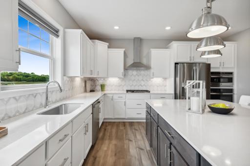 (Photos of model home, finishes will vary) Gourmet kitchen with huge island, walk in pantry and stainless appliances. This spacious gourmet kitchen features a walk-in pantry, quartz countertops, recessed lighting, LVP floors.