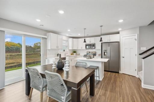 (Photo of decorated model, actual home's finishes will vary) Enjoy plenty of seating at the kitchen island and dining area adjacent to the kitchen.