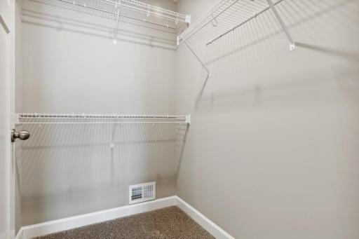 (Photo of decorated model, actual home's finishes will vary) The owner's suite features an incredible walk-in closet.