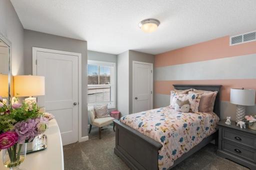 (Photo of decorated model, actual home's finishes will vary) One of the secondary bedrooms with a spacious closet!
