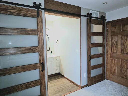New barn doors lead to ensuite 3/4 bath & walk in closet