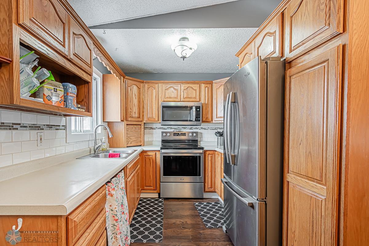 Kitchen; Dark laminate flooring & stainless appliances
