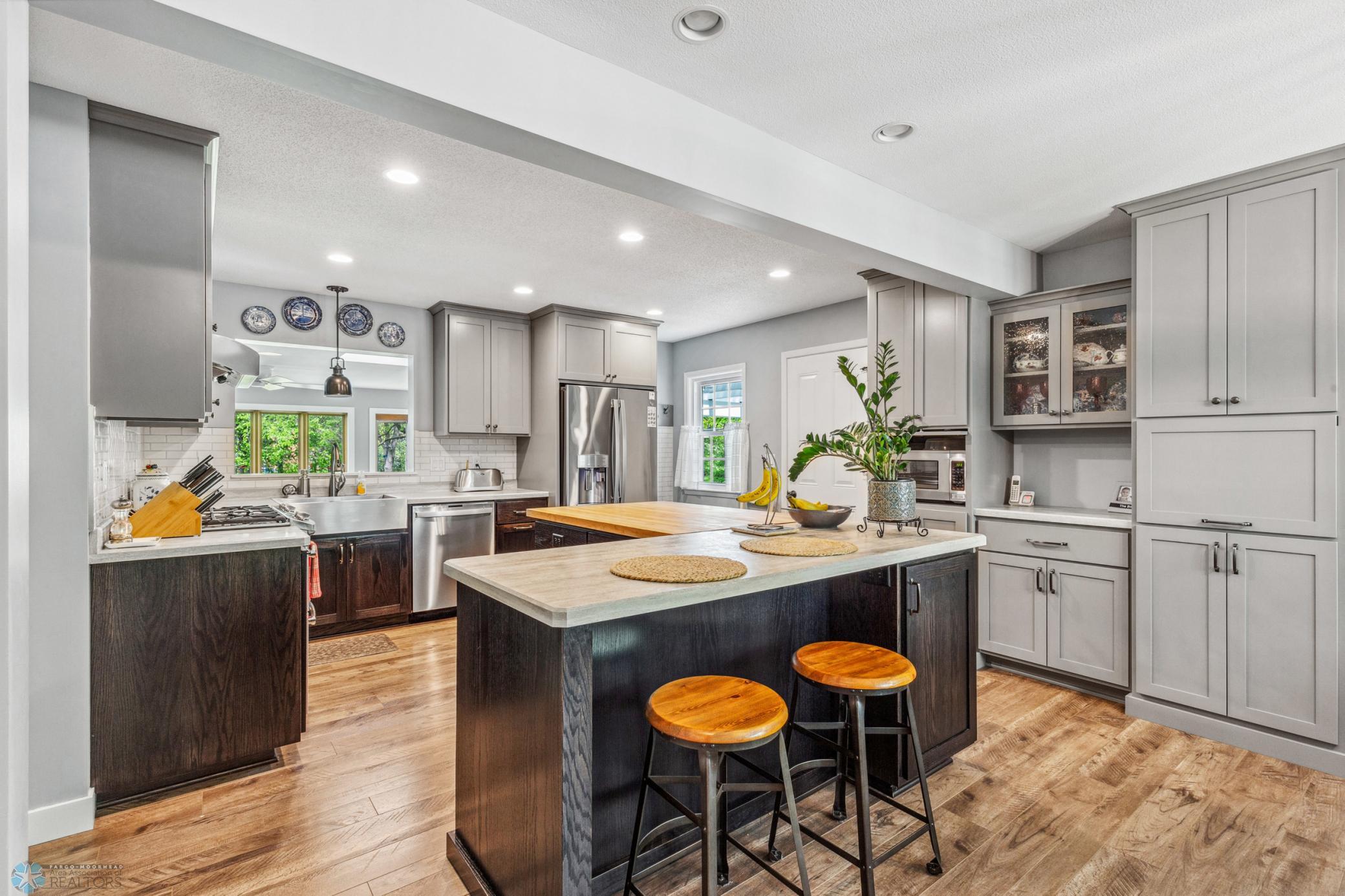 Beautifully renovated kitchen with extra large island, gas range, tile backsplash and plenty of storage