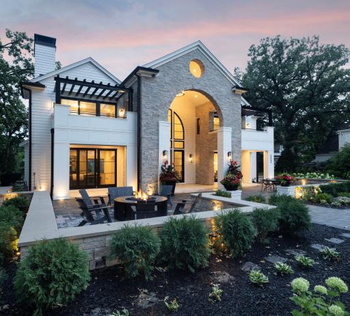 Beautiful landscaping, a built in firepit, and an expansive patio make the front of the house the perfect place to entertain.