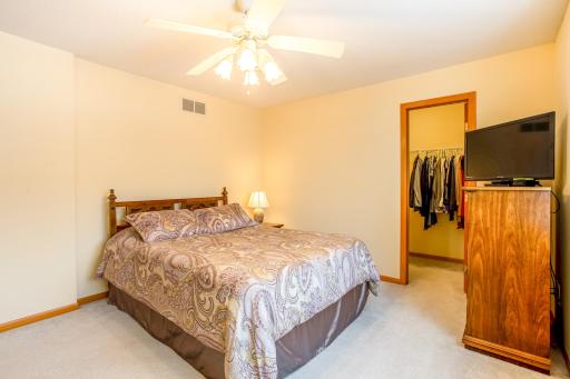 Upper-level master bedroom with large walk-in closet and ceiling fan.