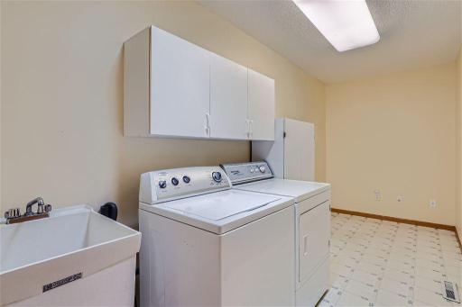 The laundry room is off of the garage entrance door and includes a utility sink + extra storage space