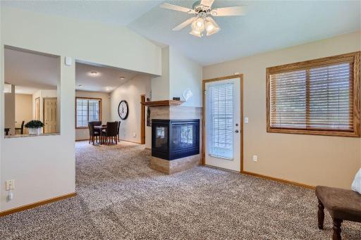 View of the gas fireplace from the sunroom and a view of the brand-new carpeting throughout the home