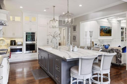 The center island, crowned with a marble countertop and offering seating for five, is the heart of the kitchen.