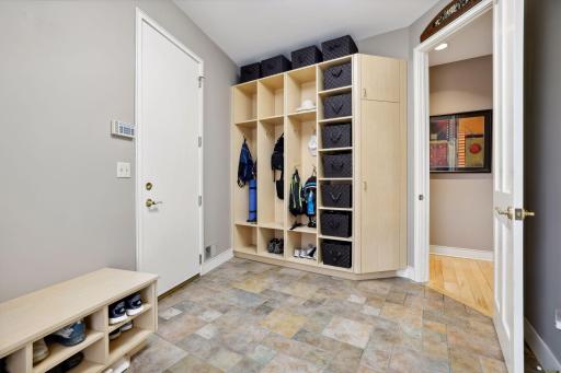 Mudroom off of the garage with built-in storage and boot bench