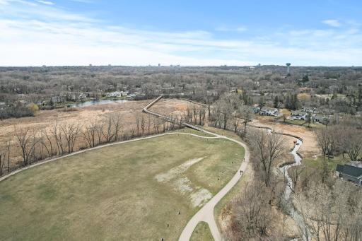 An open park setting with a playground as you walk the trail and take in views of the creek.