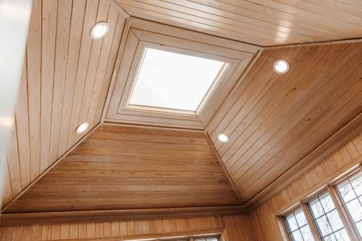 More detail in this well lit, sky light, knotty pine room.