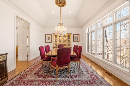 The formal dining room is adorned with a beautiful chandelier, and floor to ceiling windows for all the natural light!