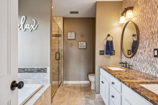 Owner's bath with dual sink vanity, granite counter, tiled flooring and accented walls.