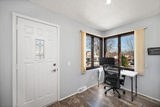 The front entry offers a heated porch. Great flex space for office, toys, and reading nook. Opposite the desk in the photo is a generous drop zone for shoes and coats! 8541 Kennedy Memorial Drive, Saint Bonifacius, MN 55375