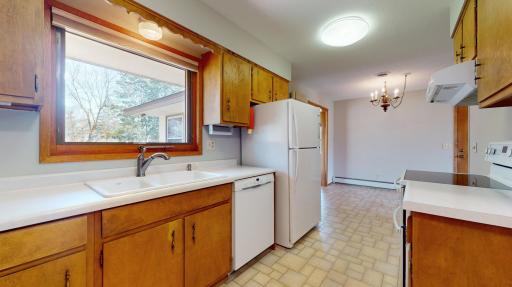 Sunlight pours through the kitchen window, bathing the space in inviting warmth. This cheerful ambiance complements the wide countertops, offering ample room for meal preparation or enjoying a leisurely cup of coffee in the morning.