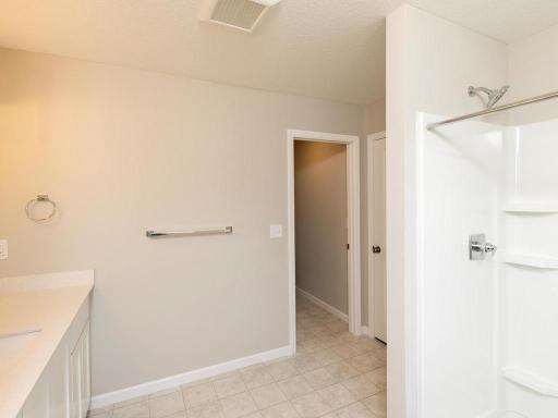 Photo taken of different home with similar plan & finishes virtually staged. Primary suite bath features a separate private stool closet with door and spacious 5' shower.