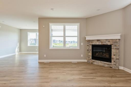 (*Photo of similar home, actual homes colors and finishes will vary) The stone fireplace is a beautiful focal point in this space