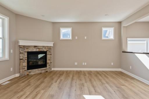 (*Photo of similar home, actual homes colors and finishes will vary) Another view of the corner fireplace in the Great Room