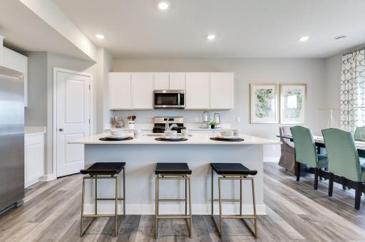 The heartbeat of the kitchen - this Island has loaded of counter space all coated in quartz counter-tops with an overhang large enough to fit a handful of bar stools! Photo of model, colors & options will vary.
