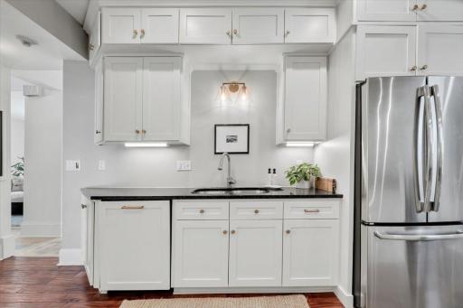 Updated kitchen with enameled white cabinetry and stainless appliances