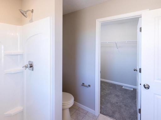 Photo taken of different home with similar plan & finishes. Primary Bath and Walk-in Closet.