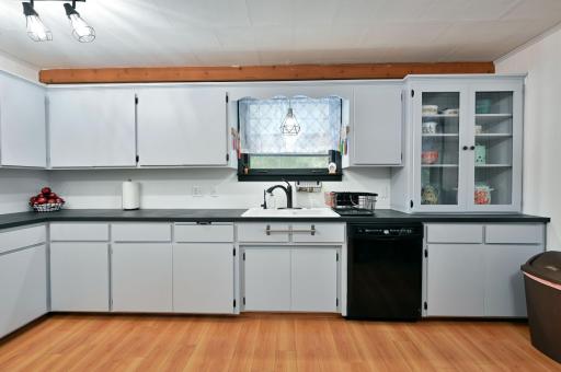 The spacious kitchen has an abundance of cabinetry including a glass display cabinet.