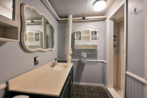 The bathroom has a long vanity and ceramic tile flooring.