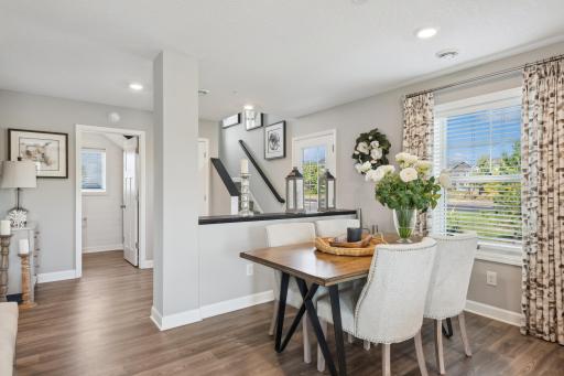 (Photo of a decorated model, actual homes finishes will vary) Situated conveniently next to the kitchen is a dining room with a comfortable setup for a table and chairs.