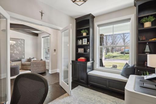 First floor office with french door entry, built-in shelving and window seat.