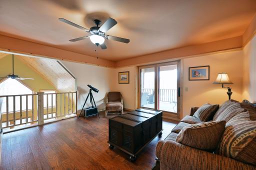 The open loft is a great flex space. It has a ceiling fan with sliding doors going out to another deck.