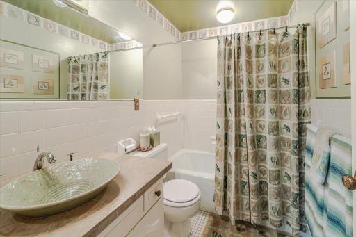 This full bath lies off the hall to be used by the secondary bedrooms, and includes tile flooring and a vessel bowl sink.