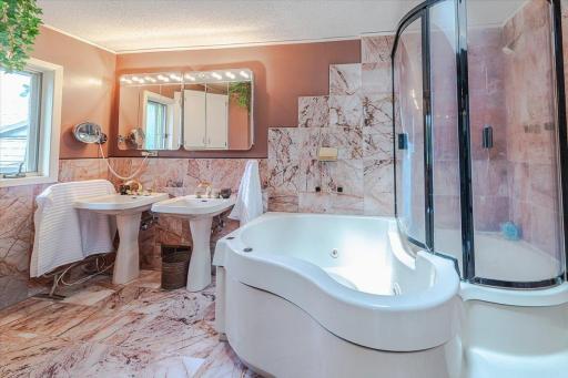 The private full bath has Italian marble flooring and dual sinks, a shower with hot-tub, skylight window and a walk-in closet.