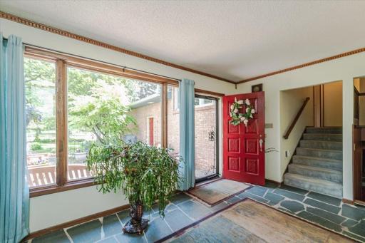 Another view of the foyer with its picture window and flagstone tile floor. Notice the red carved door!
