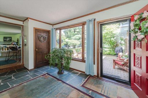 An oversized Andersen window in the foyer lets the light radiate into this functional entry, with flagstone tile flooring and crown molding. There is also a coat closet in this space.