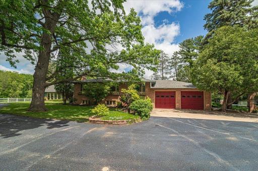 The handsome brick home offers a brick exterior and striking garage doors. Off the left side you can see the pool room. Yes! This property has an indoor pool!